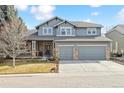 Charming two-story home showcasing a three-car garage, stone accents, and well-manicured lawn at 448 Winterthur Cir, Highlands Ranch, CO 80129