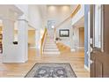 Grand foyer with hardwood floors, soaring ceilings, staircase, and elegant decor at 448 Winterthur Cir, Highlands Ranch, CO 80129