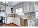 Well-lit kitchen features white cabinets, stainless steel appliances, granite countertops, and hardwood floors at 1317 S Saint Paul St, Denver, CO 80210