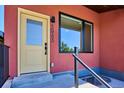 Close up of a unit's entrance featuring a yellow door and a metallic railing at 3943 W 12Th Ave, Denver, CO 80204