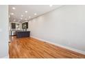 Open-concept living room with hardwood floors and modern kitchen in the background at 3943 W 12Th Ave, Denver, CO 80204