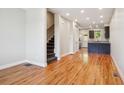 Living room with hardwood floors, staircase, and view of kitchen area at 3943 W 12Th Ave, Denver, CO 80204