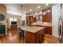 Kitchen features an island with barstool seating, stainless steel appliances, and hardwood floors at 9165 Kornbrust Dr, Lone Tree, CO 80124