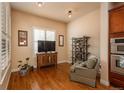 Cozy living room with hardwood floors, a comfortable armchair, and a large television at 9165 Kornbrust Dr, Lone Tree, CO 80124