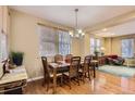 Bright dining room with a classic chandelier, wood table set, and hardwood floors at 23372 E Chenango Pl, Aurora, CO 80016