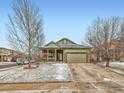 Charming single Gathering home featuring a covered porch with stone accents and a two car garage at 23236 Chapel Hill Pl, Parker, CO 80138