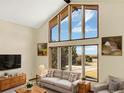 Bright living room boasts lots of natural light with large windows and vaulted ceilings at 40154 E Colorado Ave, Bennett, CO 80102