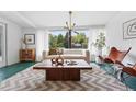 Bright living room featuring a neutral sofa, stylish decor, and a large window with outdoor views at 2675 S Eudora St, Denver, CO 80222