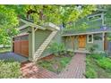 Front exterior view featuring a brick pathway, wood-paneled garage door, and hanging flower basket at 3966 Bosque Ct, Boulder, CO 80301