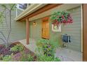 A covered front porch entry featuring a wood door, hose and flourishing plant at 3966 Bosque Ct, Boulder, CO 80301