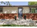 Close up of exterior home with brick accents, well manicured lawn, and front entryway at 6470 Field St, Arvada, CO 80004