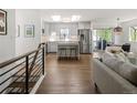 Open concept kitchen, dining and living space with wood floors and stainless steel appliances at 6470 Field St, Arvada, CO 80004