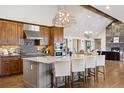 Gourmet kitchen boasts granite island, custom cabinetry, and stainless steel appliances with vaulted ceiling at 9703 Phillips Rd, Lafayette, CO 80026
