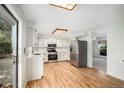 Eat-in kitchen featuring stainless steel appliances, light countertops, and wood flooring at 15892 E Arkansas Pl, Aurora, CO 80017