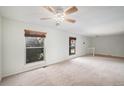 Expansive living room bathed in natural light, featuring neutral carpet and ceiling fan at 15892 E Arkansas Pl, Aurora, CO 80017