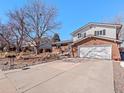 Charming two-story home with brick and siding exterior, landscaping, and a two car garage and large driveway at 2165 S Flower St, Lakewood, CO 80227