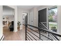 Inviting entryway featuring a stylish door, modern railing, and view to the kitchen and dining area at 8750 W 8Th Ave, Lakewood, CO 80215