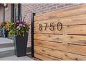 Close-up of the house number displayed on a modern wooden screen with elegant planter at 8750 W 8Th Ave, Lakewood, CO 80215
