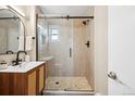 Modern bathroom featuring tiled walk-in shower with glass doors, and sleek vanity at 2930 S Birch St, Denver, CO 80222