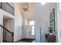 Bright foyer with high ceilings, a modern chandelier, and elegant staircase featuring wood floors at 3214 Timeless Trl, Berthoud, CO 80513