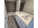 Modern bathroom featuring a double sink vanity, neutral toned tile flooring, and a shower and tub combo at 8820 Whiteclover St, Littleton, CO 80125