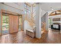Bright foyer with wood floors, staircase, and a charming bench with storage at 1423 Belford Ct, Evergreen, CO 80439