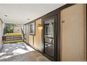 Apartment unit entrance with door, exterior wall lamp, and concrete porch at 1390 Everett Ct # 105, Lakewood, CO 80215