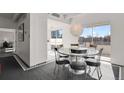 Modern dining area with a round table, six chairs, and large windows at 130 N Pearl St # 404, Denver, CO 80203