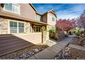 Beautiful townhome exterior with stone and siding, complemented by a landscaped walkway and blossoming tree at 5660 S Algonquian Way # C, Aurora, CO 80016