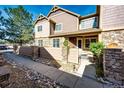 Attractive townhome with stone and siding, alongside a walkway with rock landscaping and mature tree at 5660 S Algonquian Way # C, Aurora, CO 80016
