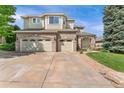 Beautiful two-story home featuring a three-car garage, brick accents, and manicured lawn at 6323 S Sicily Way, Aurora, CO 80016