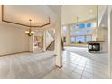 Spacious living room with fireplace, large windows, and elegant staircase at 6323 S Sicily Way, Aurora, CO 80016