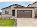 Charming single Gathering home featuring a two-car garage, stone accents, and manicured lawn at 23692 E 40Th Ave, Aurora, CO 80019