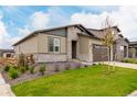 Charming single Gathering home featuring a two-car garage, stone accents, and manicured lawn at 23692 E 40Th Ave, Aurora, CO 80019