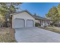 Attached two-car garage featuring neutral paint with brick accents and ample driveway space at 5749 S Lansing Way, Englewood, CO 80111