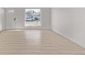 Bright and airy empty room featuring light hardwood flooring and a large window at 16555 E Wesley Ave, Aurora, CO 80013