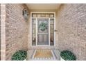 Close-up of the elegant front door featuring sidelights, a wreath, and a welcoming mat at 1274 Meyerwood Ln, Highlands Ranch, CO 80129