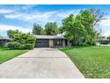 Long driveway leads to a two-car garage, with well-kept lawn and established landscaping at 400 S Hoyt St, Lakewood, CO 80226
