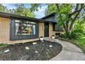 Brick home with black accents and lush front yard plants create a welcoming feel at 400 S Hoyt St, Lakewood, CO 80226