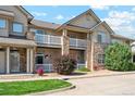 Inviting condo exterior with stone accents, white railings, and well-maintained landscaping at 10818 Cimarron St # 1102, Firestone, CO 80504