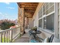 Charming porch with stone supports, seating, and view of the neighborhood at 10818 Cimarron St # 1102, Firestone, CO 80504
