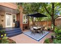 Private patio with brick paving, a dining set, and lush greenery; ideal for outdoor entertaining at 2 S Monroe St, Denver, CO 80209