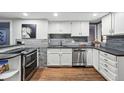 Modern kitchen with white cabinetry, stainless steel appliances, and grey backsplash at 1165 N Pennsylvania St # G2, Denver, CO 80203