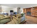 Cozy living room features a brick fireplace, comfortable seating, and wood flooring at 1165 N Pennsylvania St # G2, Denver, CO 80203