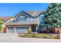 Charming two-story home with a brick and siding exterior and a well-manicured front yard at 14533 W 69Th Pl, Arvada, CO 80004