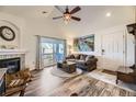 Living room with fireplace, balcony access, and wood-look floors at 23406 E 5Th Pl # 203, Aurora, CO 80018