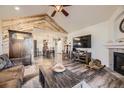 Open-concept living room featuring vaulted ceiling, a rustic wood accent wall, and wood-look flooring leading to the dining area at 23406 E 5Th Pl # 203, Aurora, CO 80018