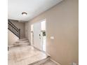 Inviting entryway with tile flooring, staircase, and a white front door at 5573 S Taft St, Littleton, CO 80127