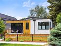 Modern home featuring unique architecture, beautiful wood siding and black trim, and a well-maintained lawn with wood fencing at 2025 Fenton St, Edgewater, CO 80214