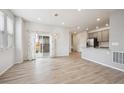 Open dining area with hardwood floors, stylish chandelier, and sliding glass doors to the backyard at 3831 E 141St Ave, Thornton, CO 80602